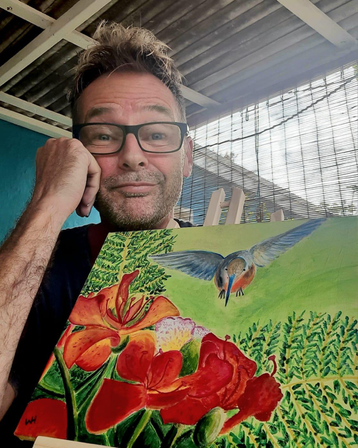 Deelnemer aan een tekenles met zijn schildering van een kolibrie en bloemen